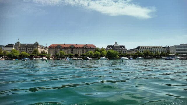 Zurich and the view from Lake Zurich in Switzerland. Buildings along the lakeshore are visible in the distance.