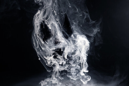 White smoke dissolving in dark water