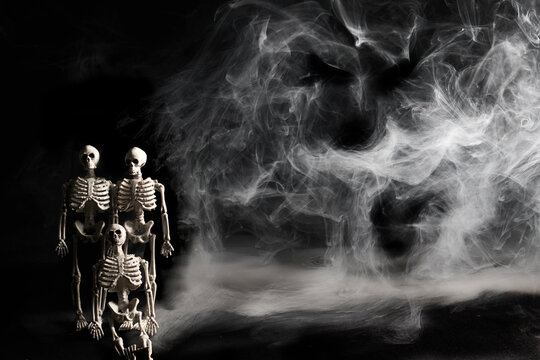 Skeletons standing in dark smoke with bat silhouette
