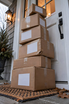 Tall Pile of Cardboard Parcels Leaning Against Front Door After Online Shopping