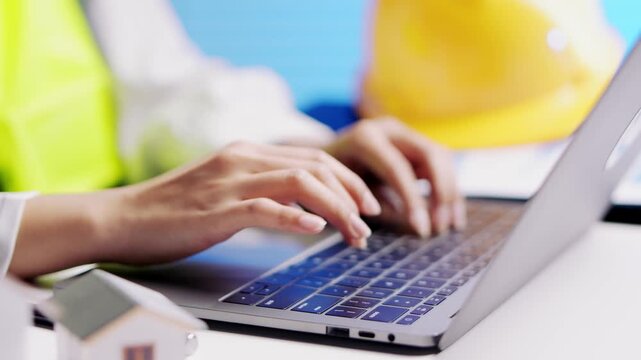 Professional architect engineer typing on laptop computer keyboard for construction project planning engineering design at modern office site