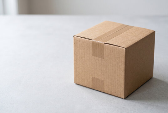 Closed cardboard shipping box with paper tape and copy space