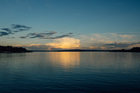 beautiful yellow light from cloud reflecting onto blue Puget Sound water 