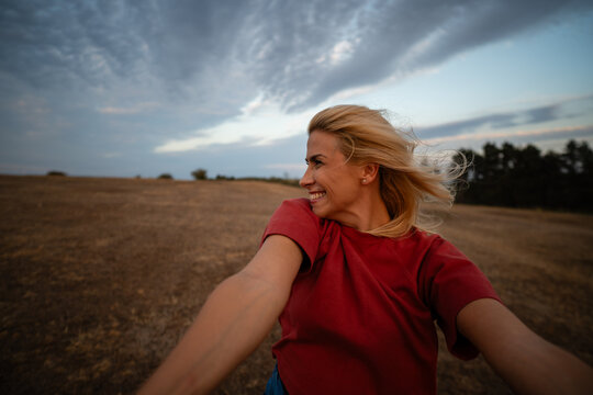 Happy young woman enjoying freedom in field
