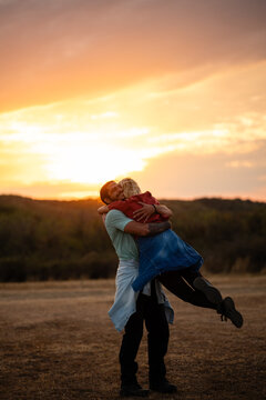 Loving couple embracing during golden hour sunset outdoors