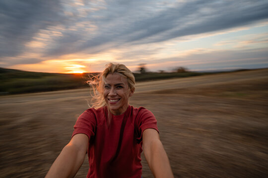 Woman spinning happily outdoors during sunset with motion blur