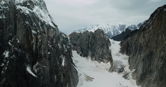 Aerial view of the rugged snow-covered peaks and glacial valleys of Mount McKinley, captured from a small plane in Denali Borough, Alaska, United States.