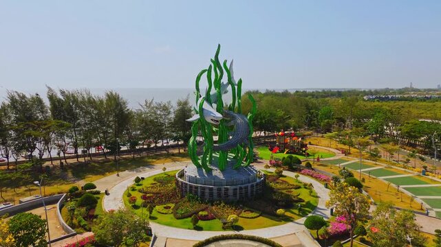 Aerial view of the iconic Patung Suroboyo Raksasa shark and crocodile statue surrounded by lush greenery and a circular park in Surabaya, East Java, Indonesia.