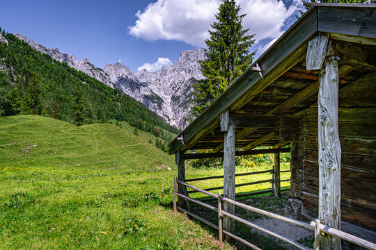 Uralte h&ouml;lzerne Almh&uuml;tte auf gr&uuml;ner Bergwiese vor den schroffen Loferer Steinbergen oberhalb des Hintersees.