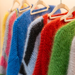 winter fashion of Colourful mohair cardigans on a clothes rack in a department store © Natascha
