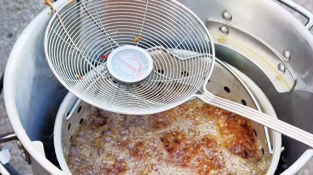 Close Up Chicken Wings Frying Beneath Wire Skimmer