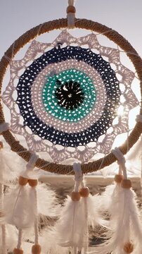 Boho dream catcher swaying wind closeup sunrise light sea background freedom lifestyle spiritual decoration footage vertical video