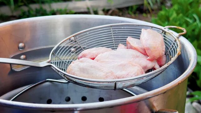 Raw Chicken Wings Loaded Into Outdoor Deep Fryer