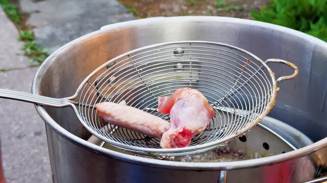 Raw Chicken Wings Dropped Into Bubbling Hot Oil