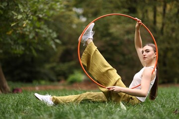 Athletic young woman posing with hula hoop in park © New Africa