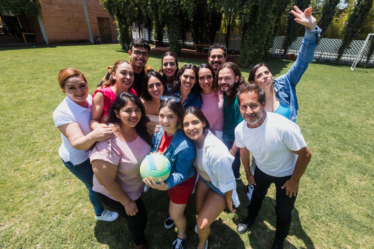 group of latin friends playing volleyball game in public park in Mexico Latin America. multicultural hispanic teamwork having fun together outdoors