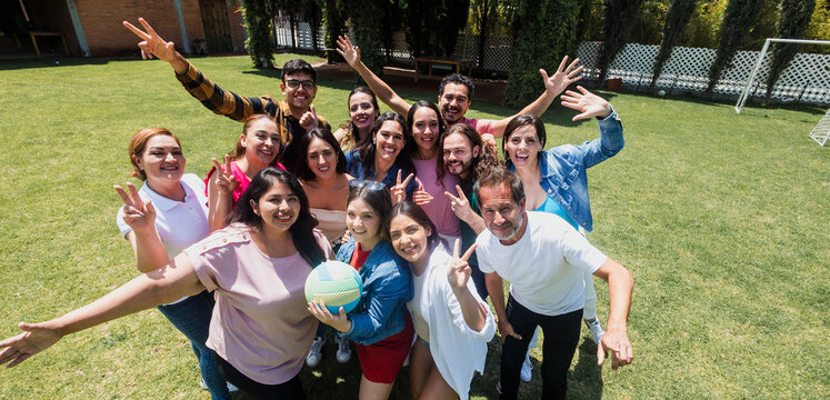 group of latin friends playing volleyball game in public park in Mexico Latin America. multicultural hispanic teamwork having fun together outdoors