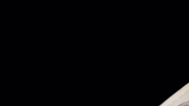 Floating white papers scattering in mid air on a black background.
