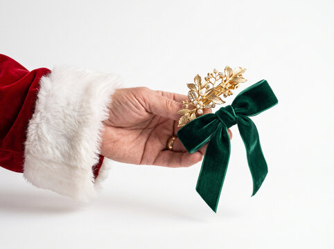 Santa Claus hand holding a festive Christmas hair accessory