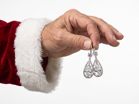Santa Claus hand holding a pair of diamond earrings