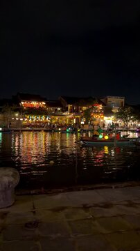 Hoi An River at Night with Lantern Boats Passing and Colourful Lights, Vietnam