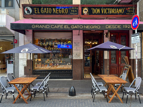 Facade and sidewalk tables of El Gato Negro coffee shop