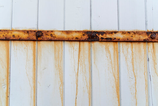 Rusted Metal Hinge and Stains on White Wooden Door Surface Texture