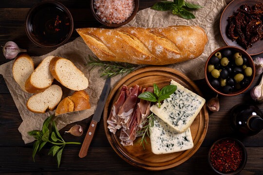 Antipasto platter with blue cheese, prosciutto, and baguette