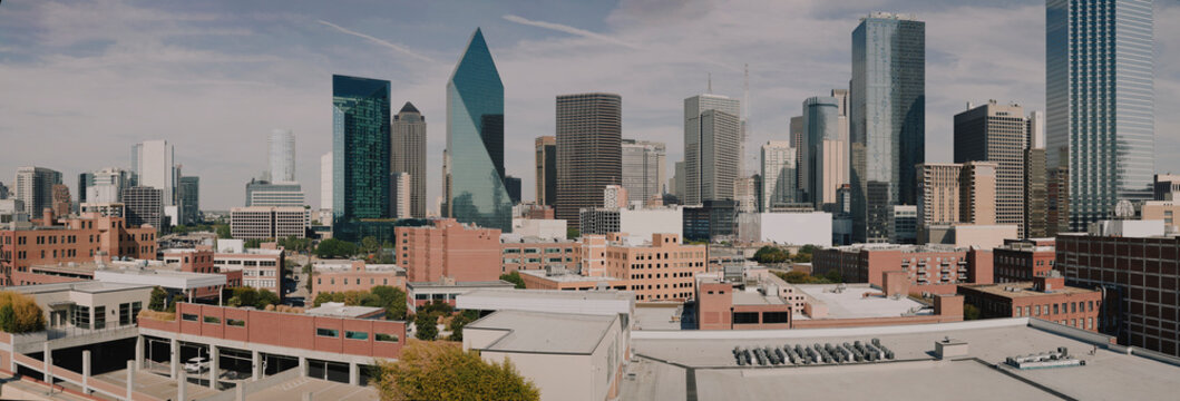 Wide panorama of downtown Dallas skyscrapers under blue sky