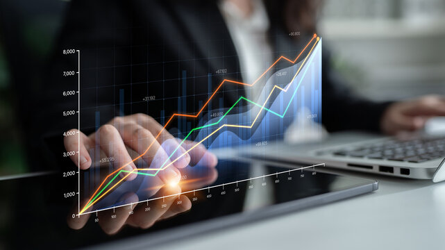 Business Professional Analyzing Financial Data With Digital Charts and Graphs on Tablet in Modern Office Environment. Bitwise.