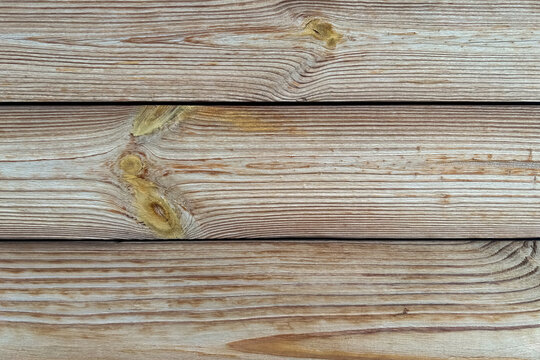 Weathered horizontal wooden planks with natural knots forming a textured background for design projects