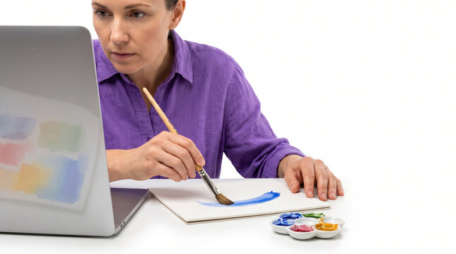 Woman painting with watercolors while learning online  