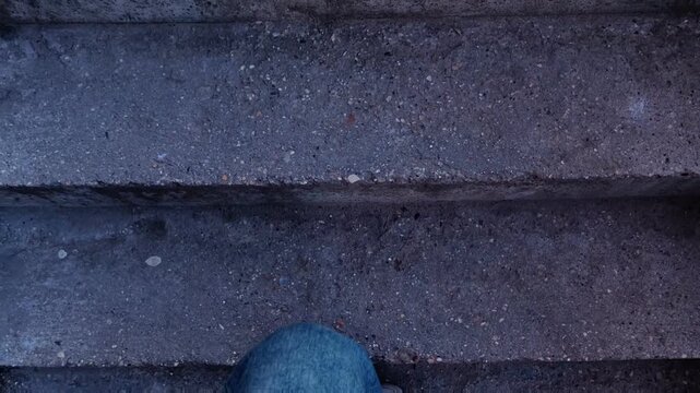 A woman climbs concrete stairs beside a residential building, urban movement, everyday city life, architectural detail, vertical video.