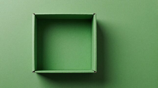 Top view of empty green cardboard box on plain background. Open square paper container provides blank space for product mockup. Minimalist eco friendly package design for gift delivery service.