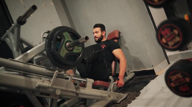 Male athlete performing 45-degree leg press exercises with weight plates focusing on quadriceps and leg muscle development.