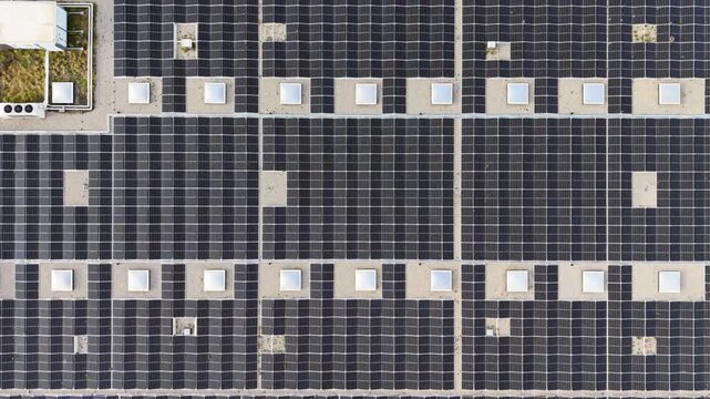 4k Aerial view solar panel facade on modern high rise with bright sun flare, glass and metal surfaces, strong geometric lines, clean energy architecture