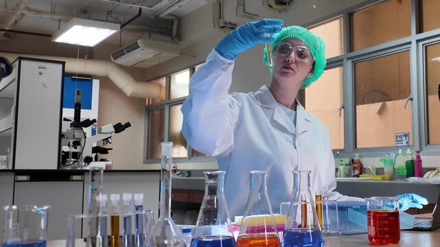Laboratory room. Female scientists conducting laboratory research with colorful chemical samples. Using test tubes flasks and microscopes for scientific analysis and experimentation. Bio or chemical