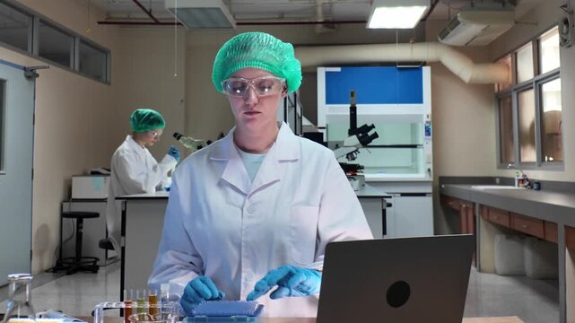 Laboratory room. Female scientists conducting laboratory research with colorful chemical samples. Using test tubes flasks and microscopes for scientific analysis and experimentation. Bio or chemical