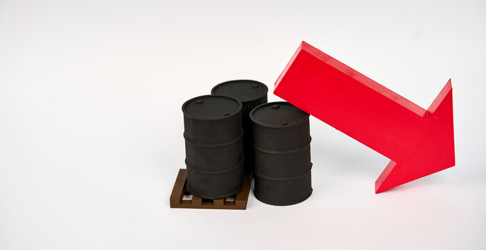 Oil barrels beside a large downward arrow representing falling petroleum prices isolated on white background.
