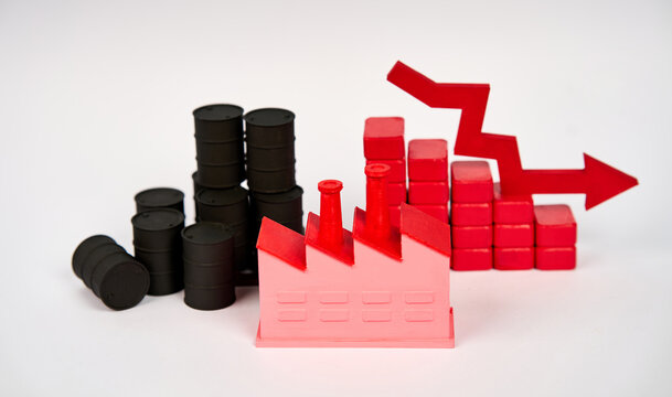 Oil barrels and factory with descending chart and downward arrow symbolizing industrial decline isolated on white background.
