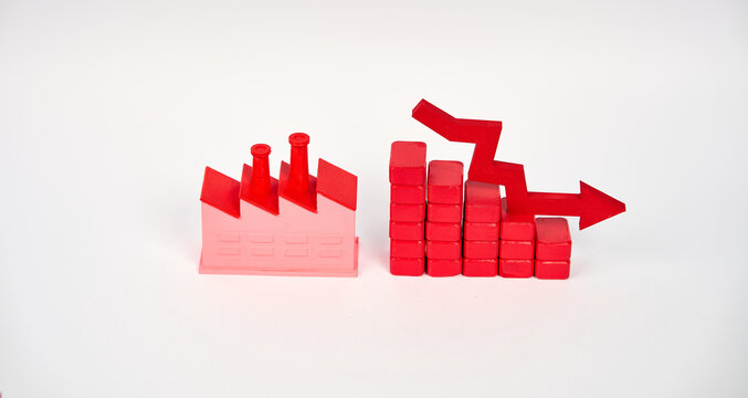 Factory beside a descending block chart and downward arrow symbolizing production decline isolated on white background.
