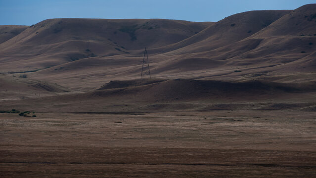 Late-afternoon mountain landscape with power pole 16:9 crop