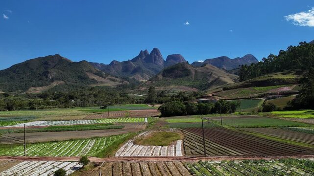 Aerial view of Tres Picos de Friburgo over agricultural fields and mountain landscape in Nova Friburgo, Rio de Janeiro, Brazil.