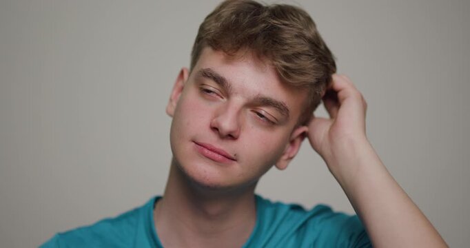Young man engaged in a thoughtful moment while sitting casually in a simple indoor setting expressing a range of emotions