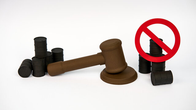 Judge gavel with prohibited oil barrels representing petroleum restrictions isolated on white background
