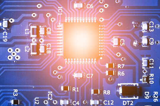 Electronic circuit board close up. Microchip and copper traces. Surface mount components and solder contacts. Digital hardware technology. Integrated processor and blue electronics background.