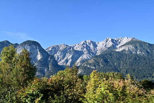 Alpine mountain range with autumn forest from moving perspective