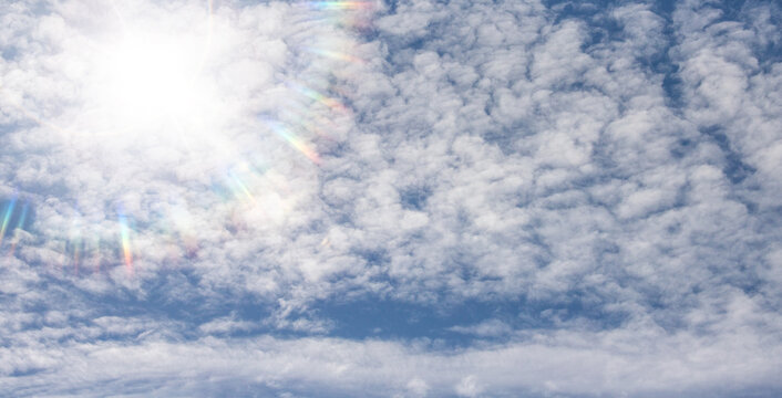 Bright sun in blue sky with white clouds background for natural design