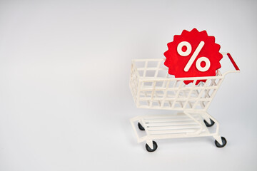 Shopping cart carrying percentage discount symbol representing retail sale and consumer savings isolated on white background  © kaliel