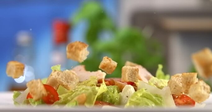 Croutons falling onto fresh caesar salad slow motion 1000 fps